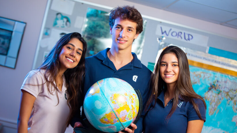 Three students by a globe
