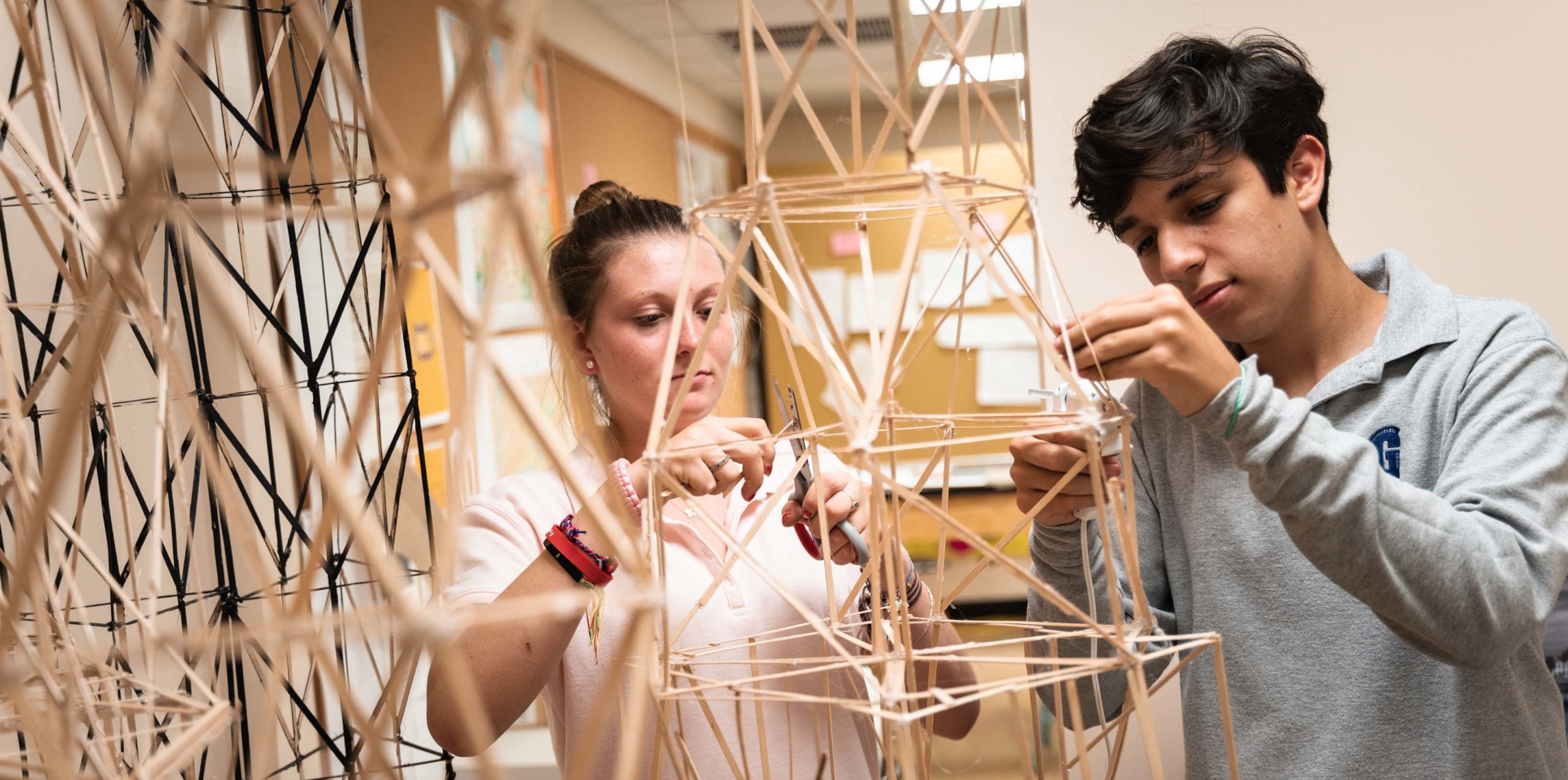 Two students building structures in architecture class
