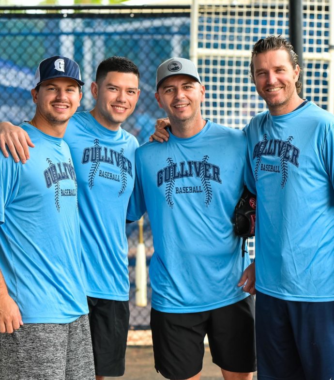 Four baseball coaches smiling