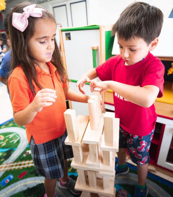 Two primary school kids building a structure with blocks