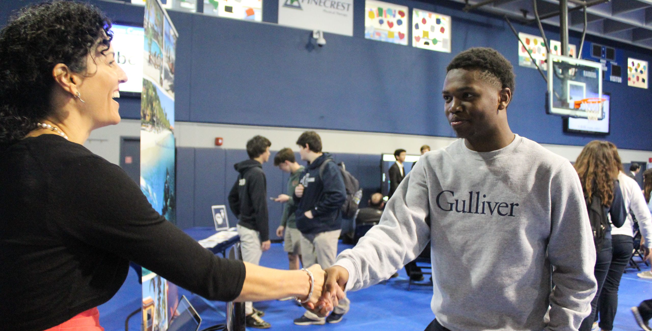 Student shaking hands with a woman at a business fair