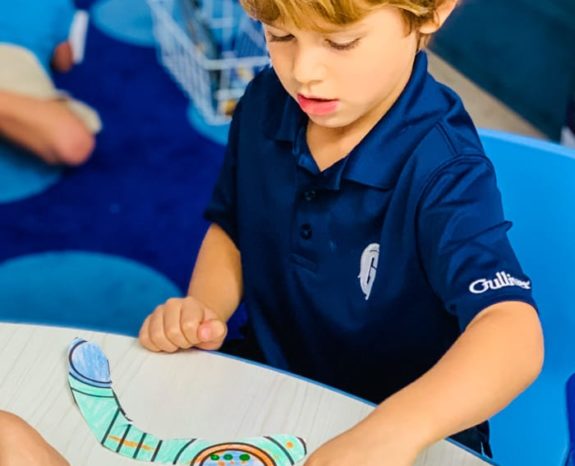 Boy coloring a paper boomerang