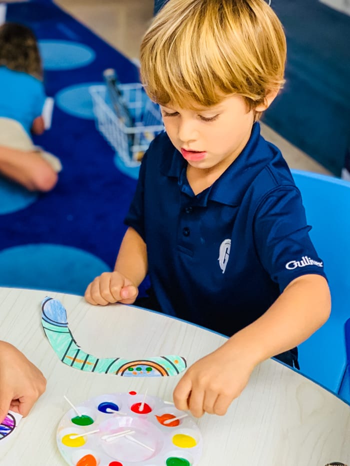 Boy coloring a paper boomerang