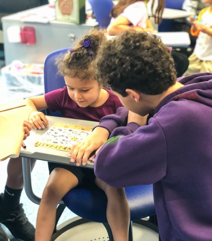 Staff helping young student learn