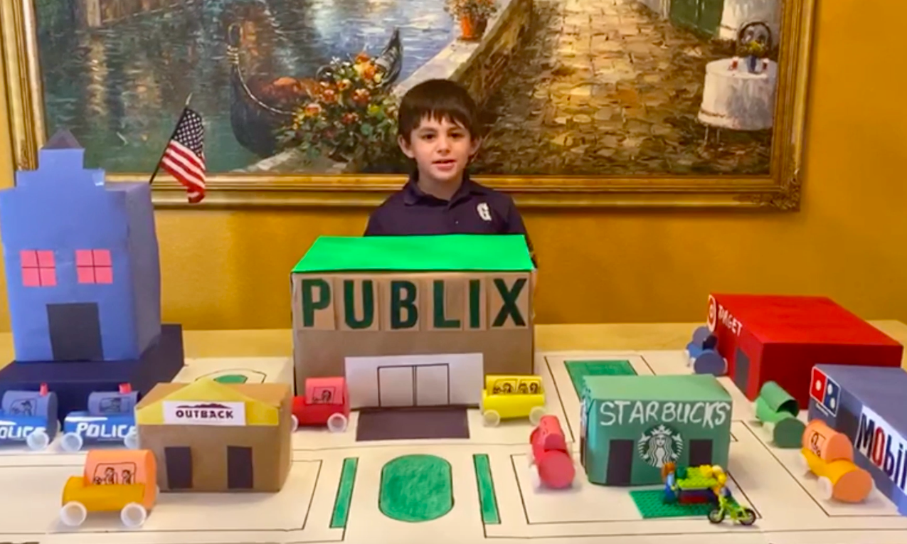 Lower school student smiles with project.