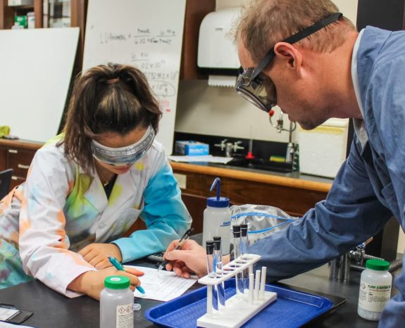 Science teacher with student in the lab