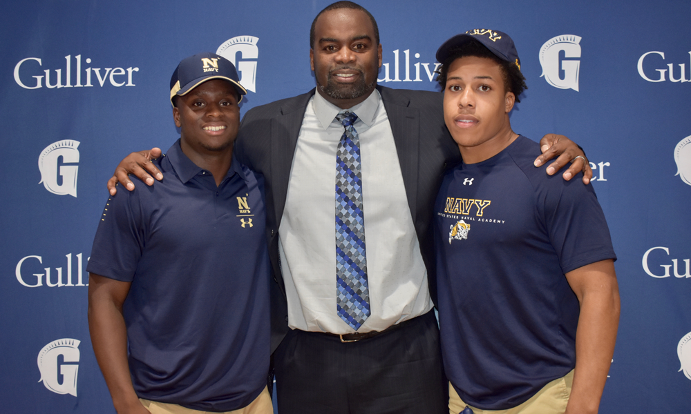 Two teenage boy football signees with coach