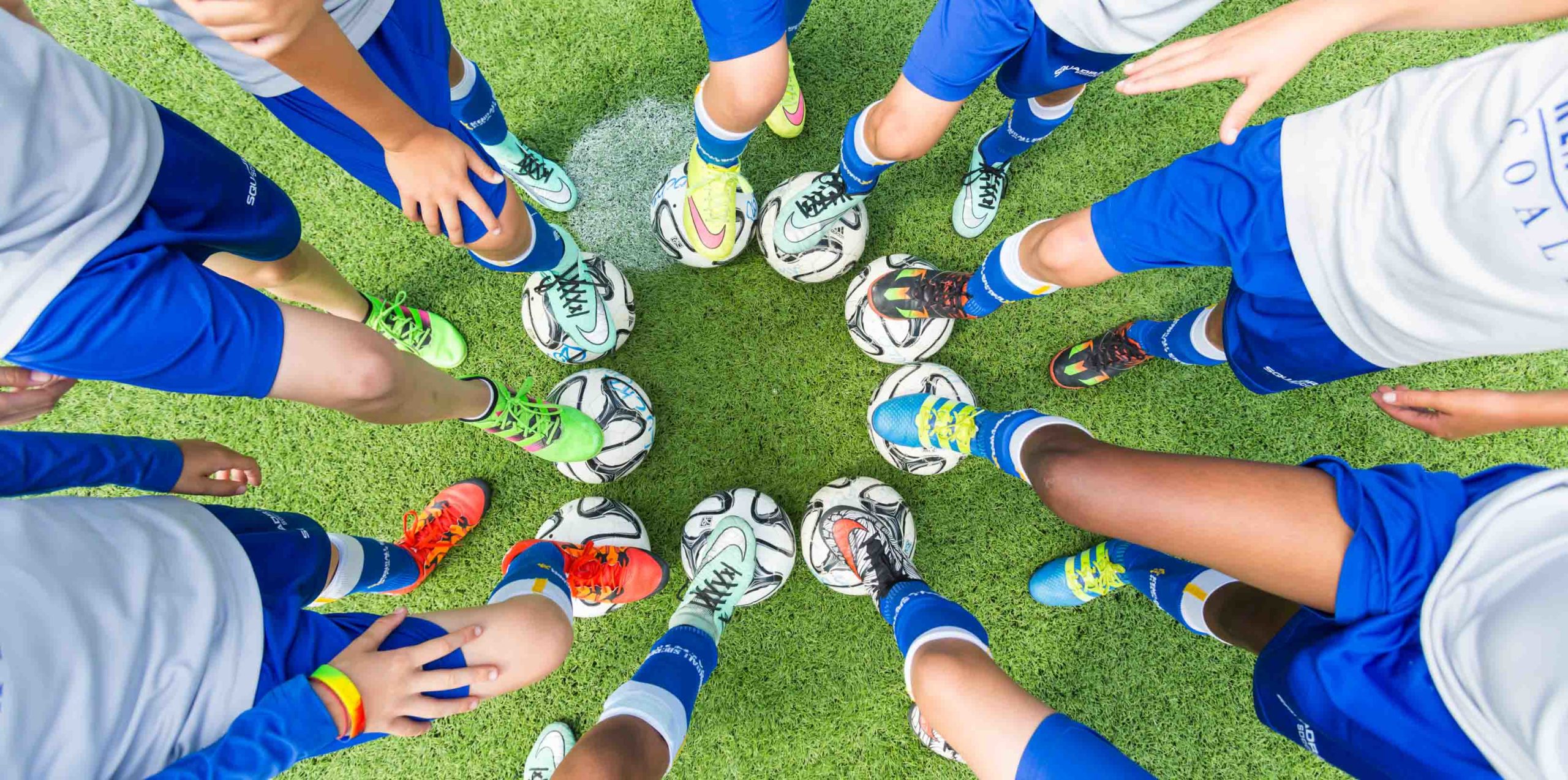 Students with feet on soccer balls