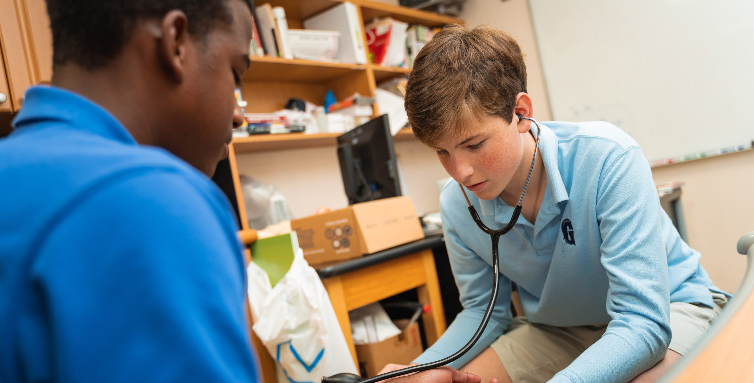 Student checking heartbeat of another student with a stethoscope