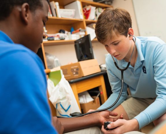 Student checking heartbeat of another student with a stethoscope