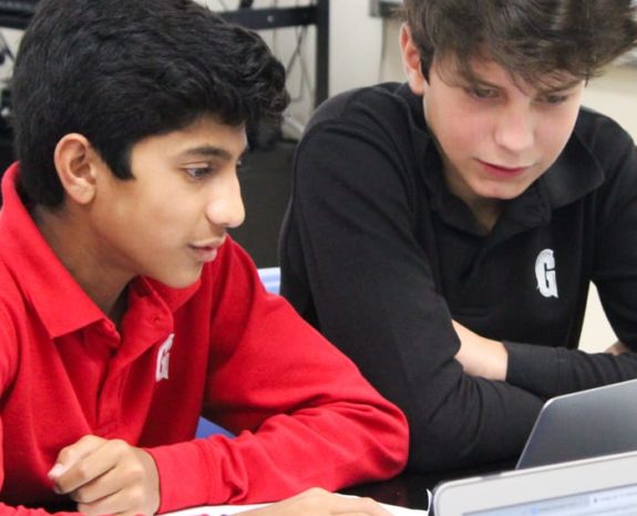 Two boys looking at a computer