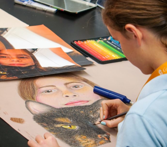 Female student painting an image of a girl with a cat