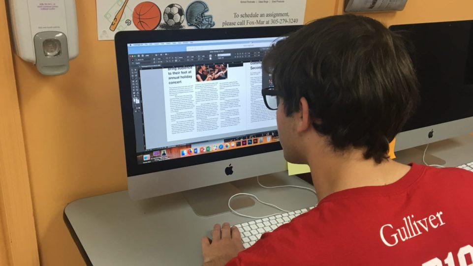 Male student working on the raiders paper on his computer