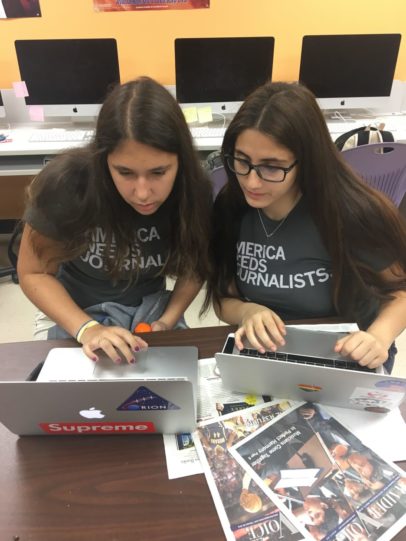 Two girls writing the raiders paper