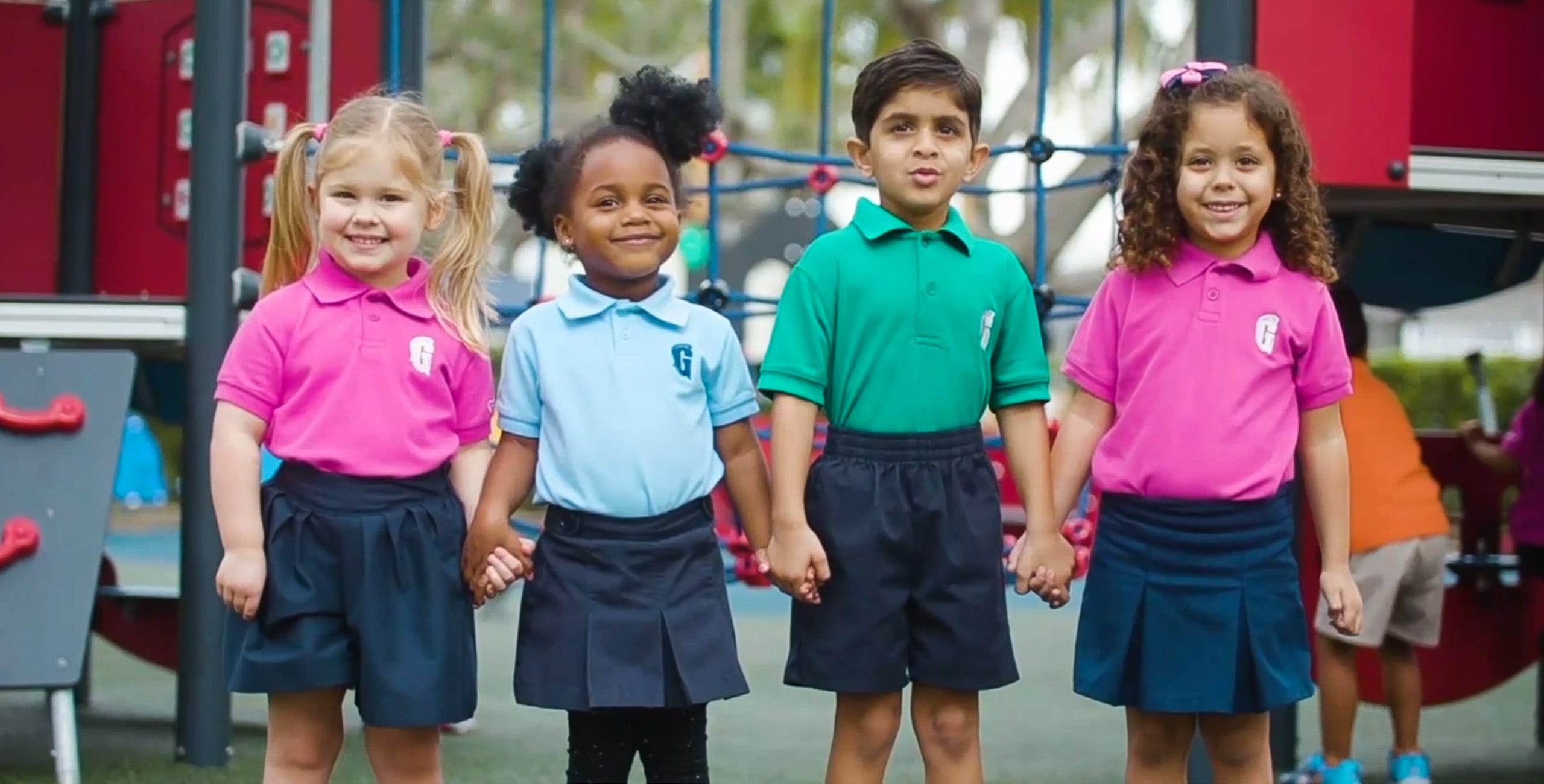 Four diverse children holding hands by the playground