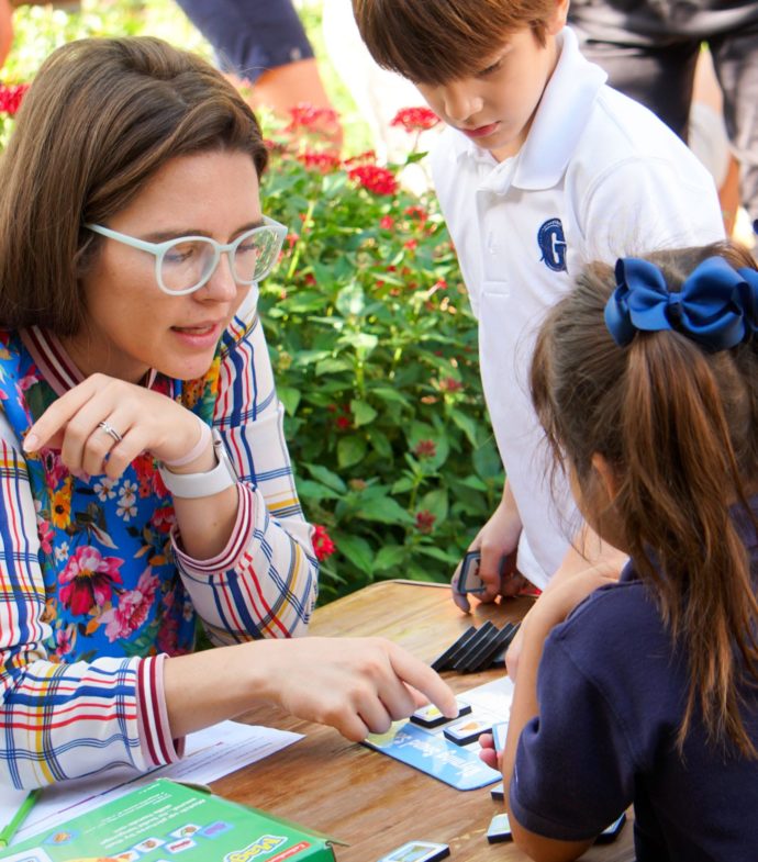 Teacher with two primary school students outside learning