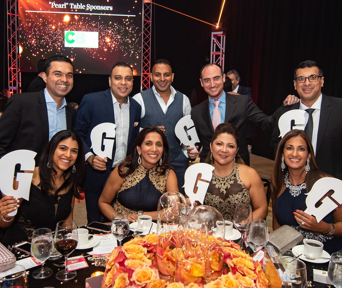 People holding Gulliver logo at the gala.