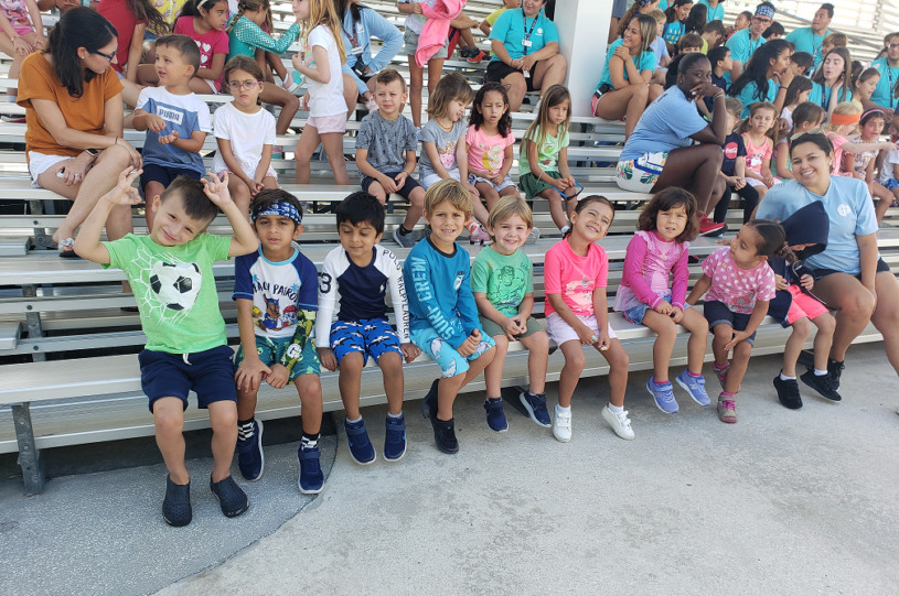 Group of students smiling on the bleachers.