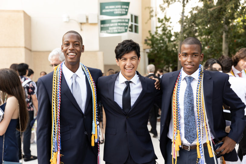 Three graduates smiling after commencement