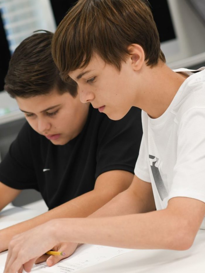 2 boys doing work in a classroom