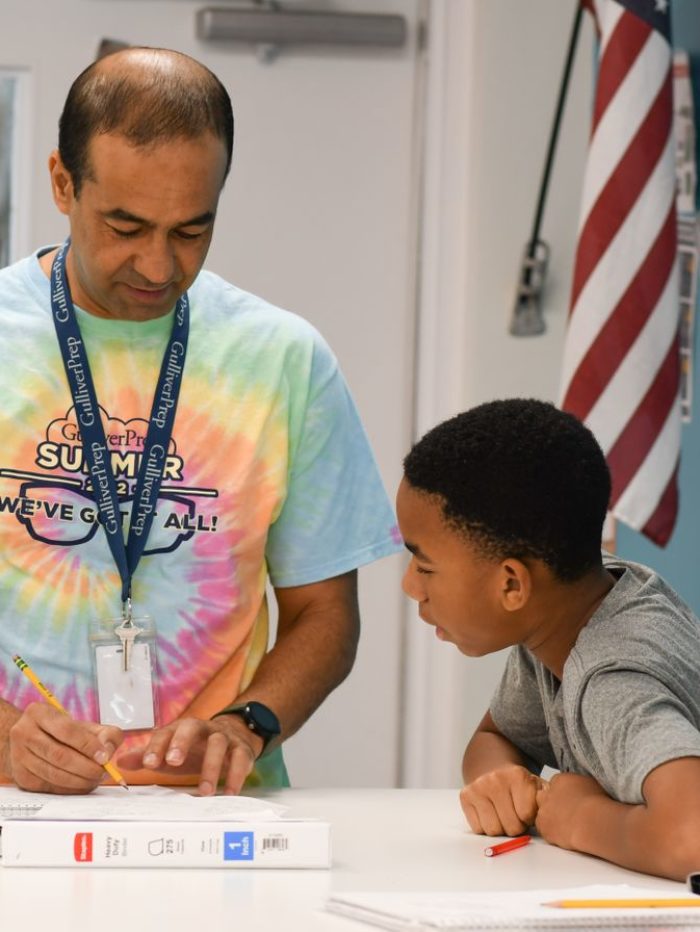Teacher in casual clothes teaching student how to do a problem