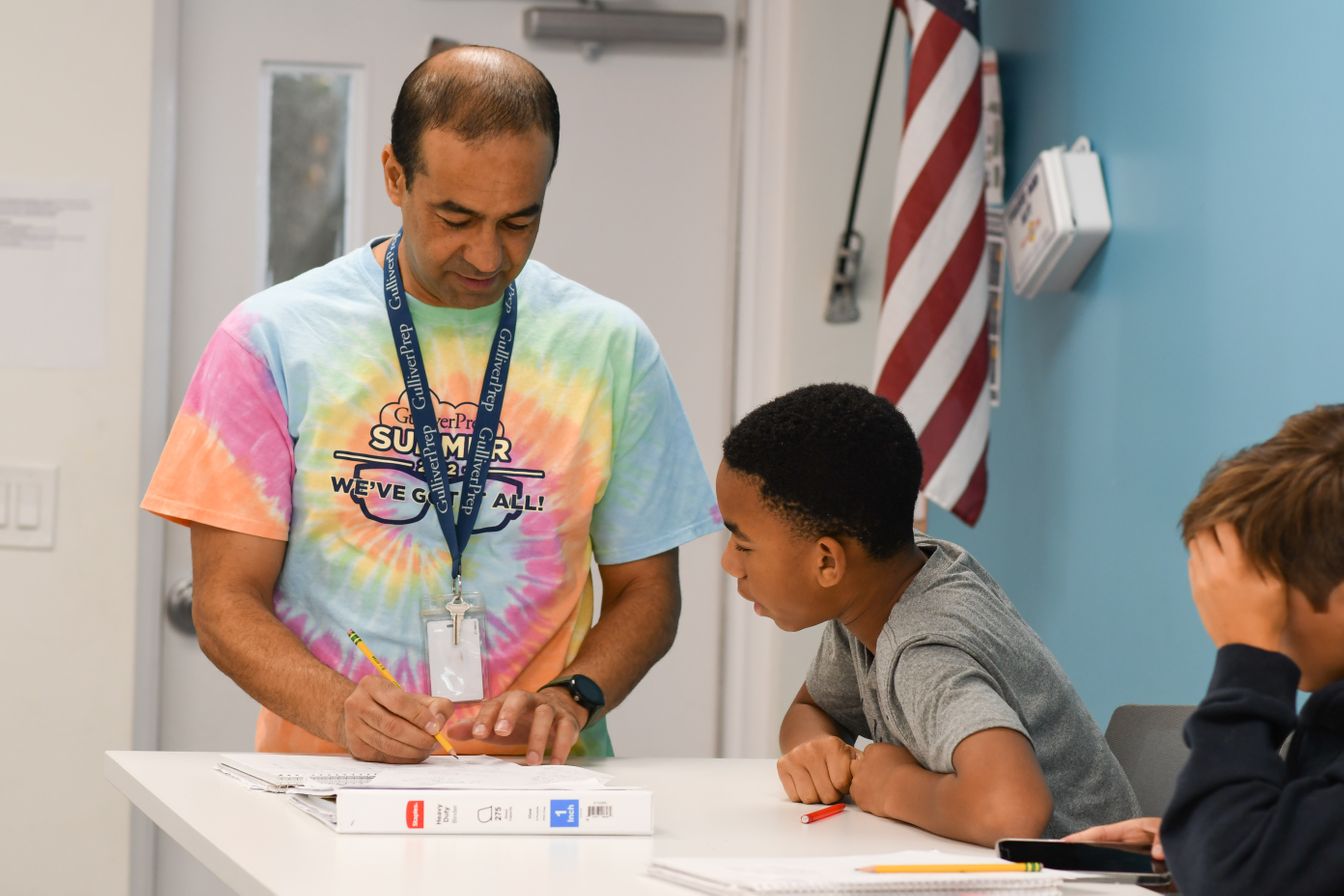 Teacher in casual clothes teaching student how to do a problem