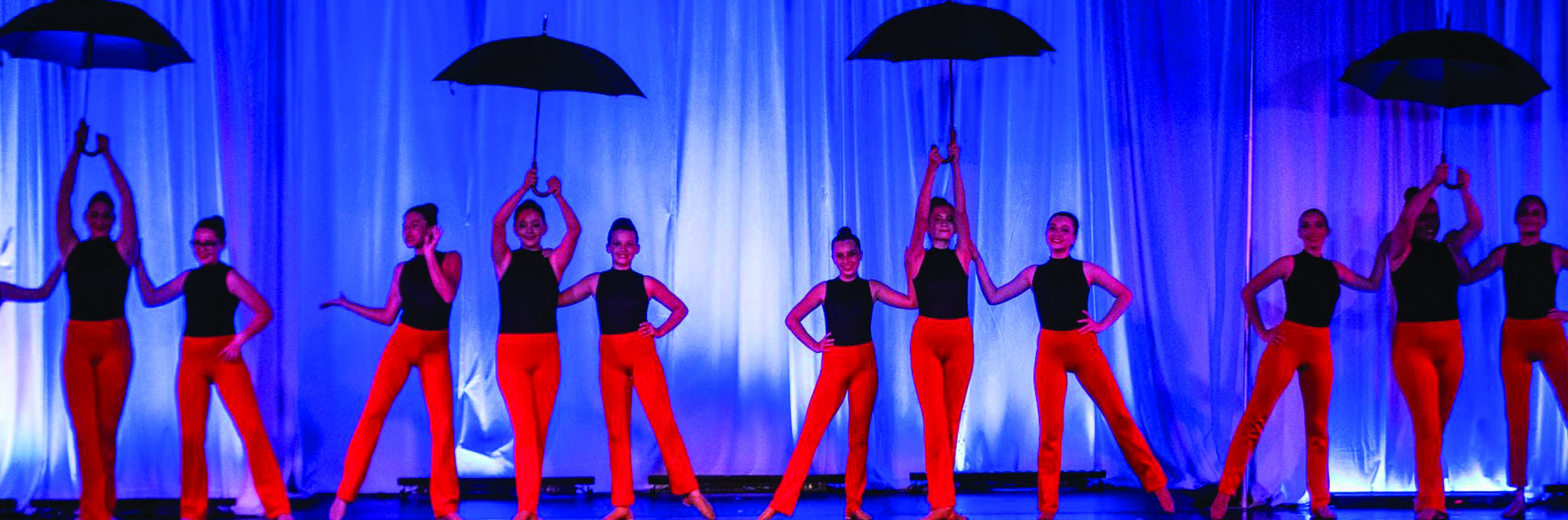 Dancers on stage with umbrellas