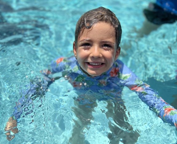 kid standing in swimming pool
