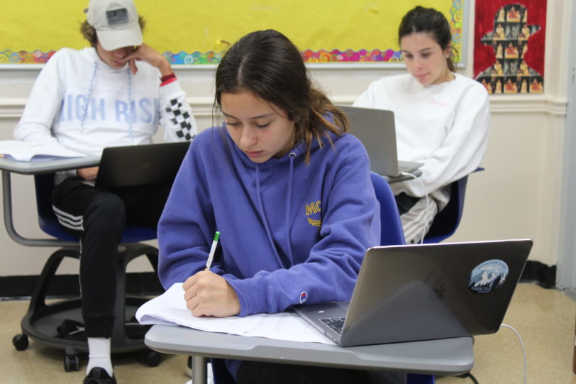 Student taking notes in class.