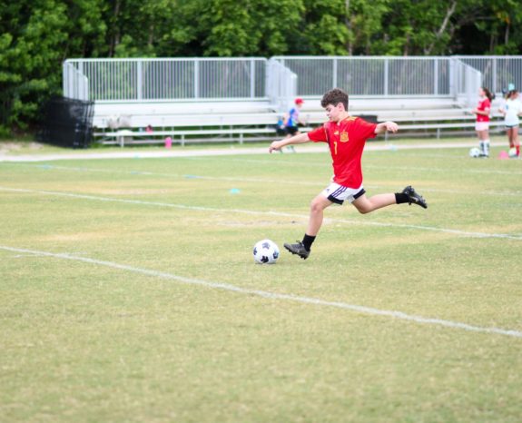 boy kicking soccer ball