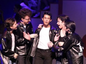 Actors performing during the production of Grease