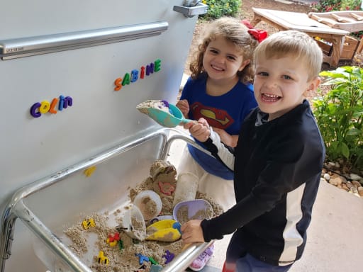 Two kids playing in a sandbox.