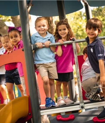 Kids lean on railing on playground